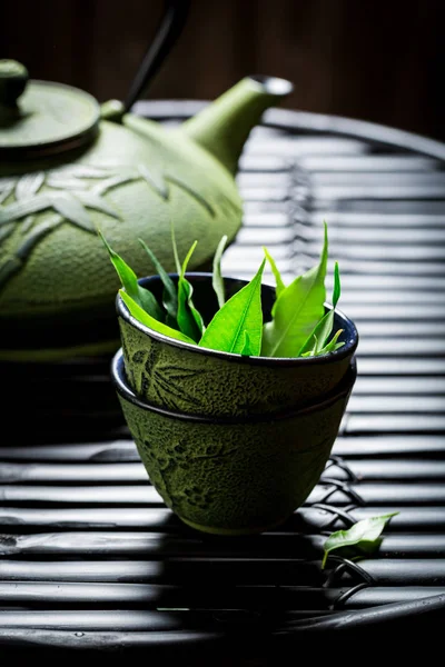 Aromatický zelený čaj s konvicí na černý stůl — Stock fotografie