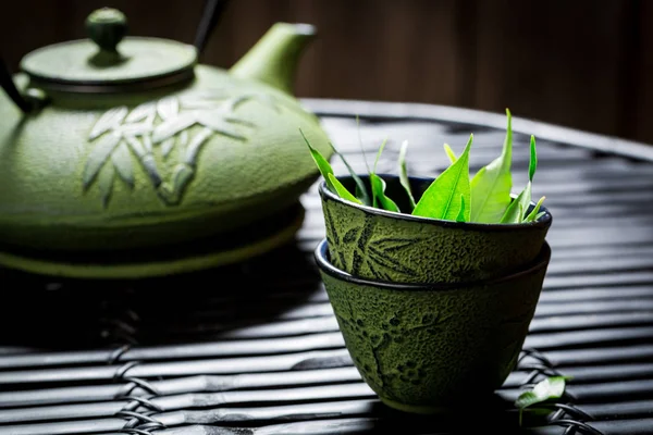 Delicioso té verde con tetera sobre mesa negra —  Fotos de Stock