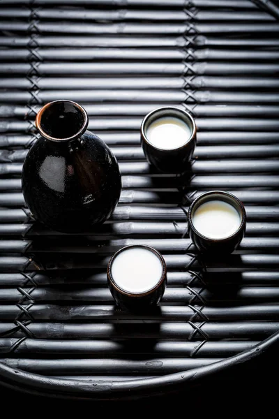 Готовы пить саке из черной керамики на черном столе — стоковое фото