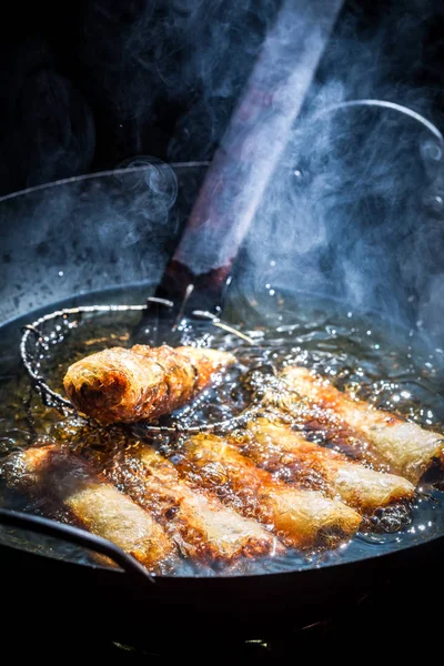 Frische Frühlingsrollen im schwarzen Wok braten — Stockfoto