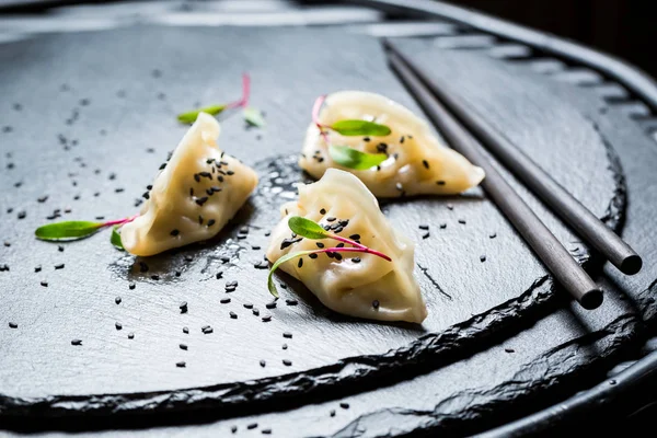 Fresh and hot gyoza dumplings on black rock — Stock Photo, Image