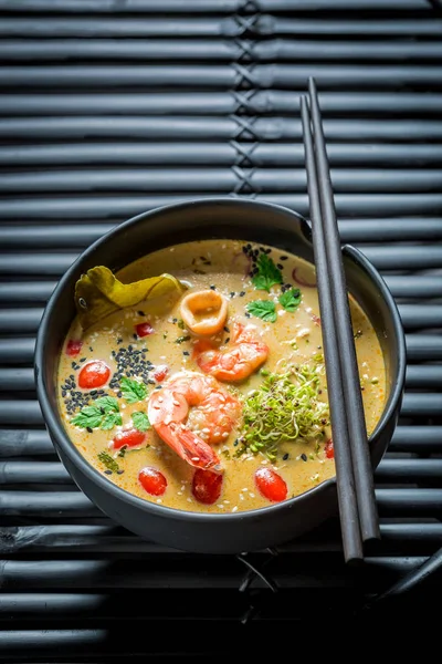 Nikmati sup Tom Yum Anda dalam mangkuk hitam dengan sumpit — Stok Foto