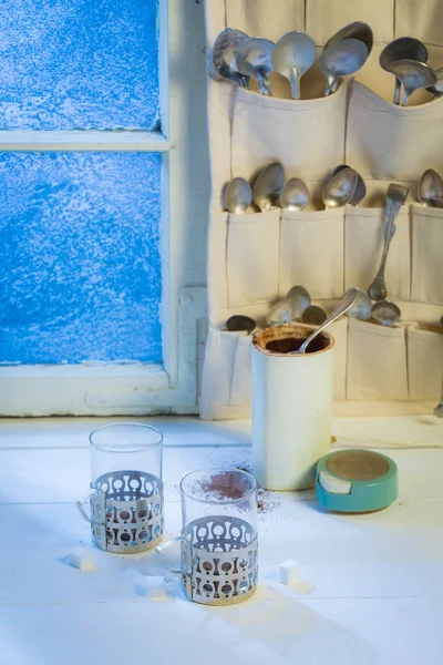Taza caliente y cafetera con cucharas en invierno —  Fotos de Stock