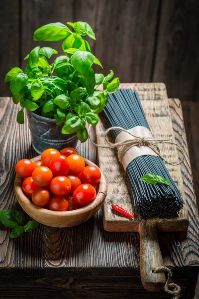 Ingredientes para espaguete preto com manjericão e tomate — Fotografia de Stock