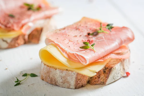 Crujir un pedazo de pan con queso y jamón — Foto de Stock