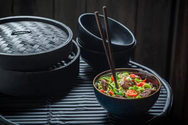 Mie Asia lezat dalam mangkuk gelap dengan sumpit — Stok Foto