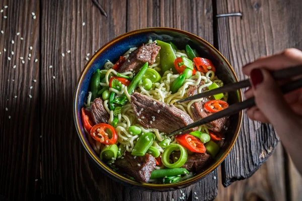 Nikmati mie Asia Anda dalam mangkuk gelap dengan sumpit — Stok Foto