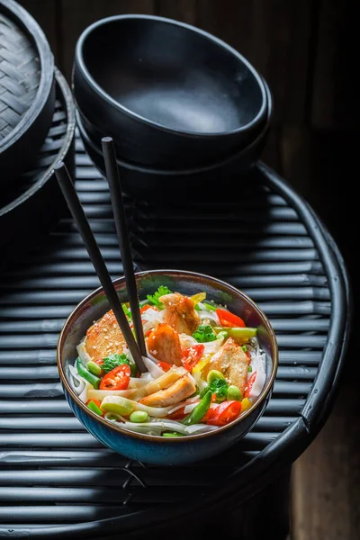 Spicy noodle in dark bowl with chopsticks — Stock Photo, Image