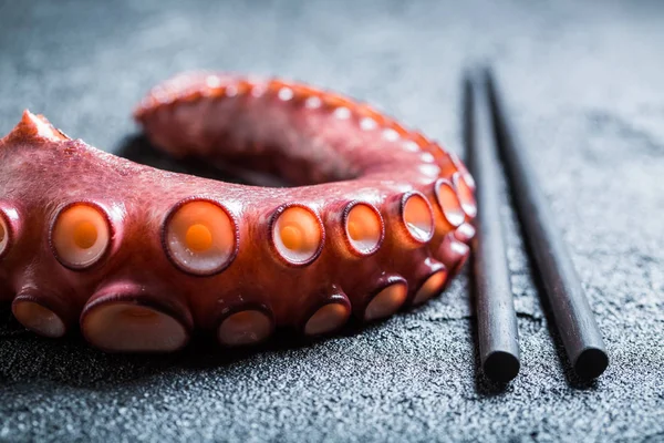 Fialová chobotnice a hůlky na černé skále — Stock fotografie