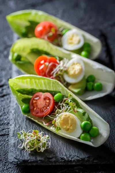 Mimořádná salát v čekanky s křepelčím vejcem, rajčaty a avokádem — Stock fotografie