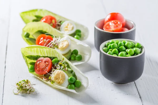 Creative salad in chicory with avocado, asparagus and peas — Stock Photo, Image