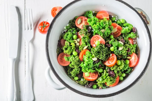 Frischer Grünkohlsalat mit Tomaten, Erbsen und Preiselbeeren — Stockfoto