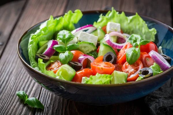 Heerlijke Griekse salade met feta, zwarte olijven en sla — Stockfoto