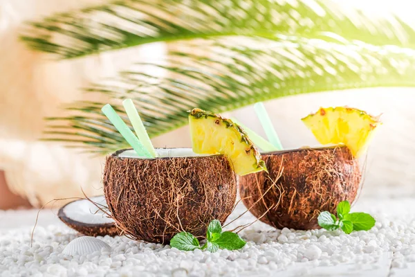 Closeup of pinacolada in coconut on sandy beach — Stock Photo, Image