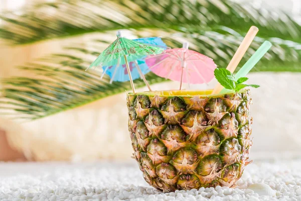 Fräsch drink i ananas på sandstrand — Stockfoto