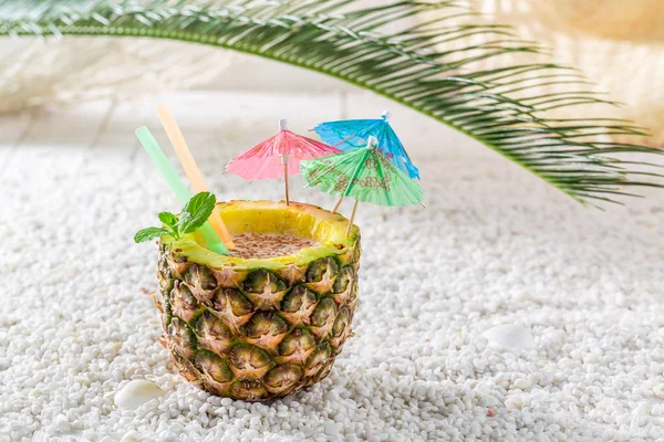 Tropisk drink i ananas med cocktail paraplyer — Stockfoto