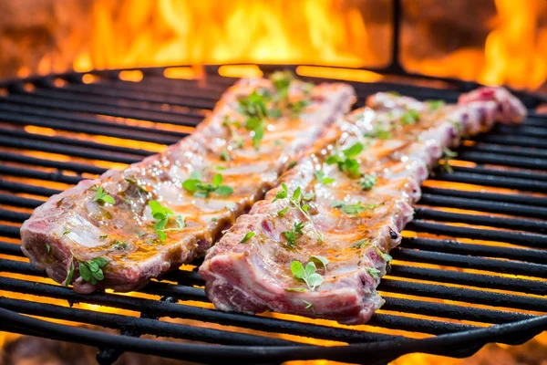 Tasty ribs on grill with thyme and spices — Stock Photo, Image