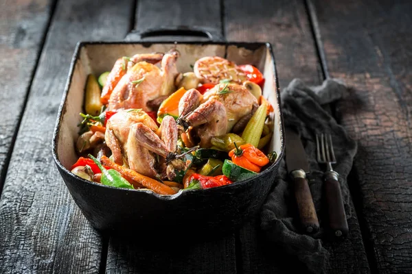 Gegrilde kwartels met groenten en kruiden in braadpan — Stockfoto