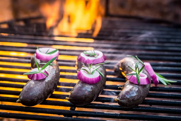 Black pudding with onion on the grill and fire — Stock Photo, Image