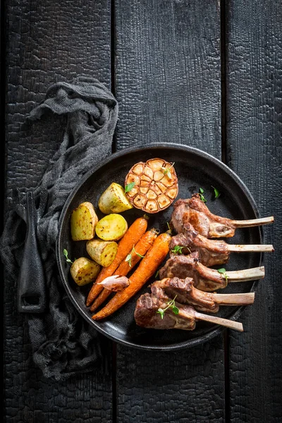 Spicy roasted lamb ribs on the burnt black table — Stock Photo, Image