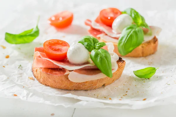 Skarpa bruschetta med prosciutto, tomat och mozzarella för ett mellanmål — Stockfoto