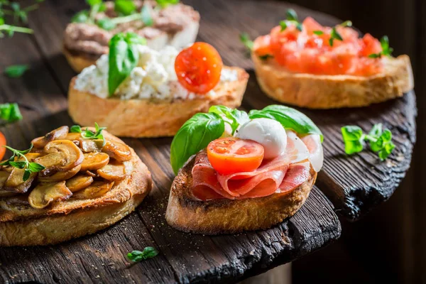 Crisp mix of bruschetta with fresh ingredients for a snack — Stock Photo, Image