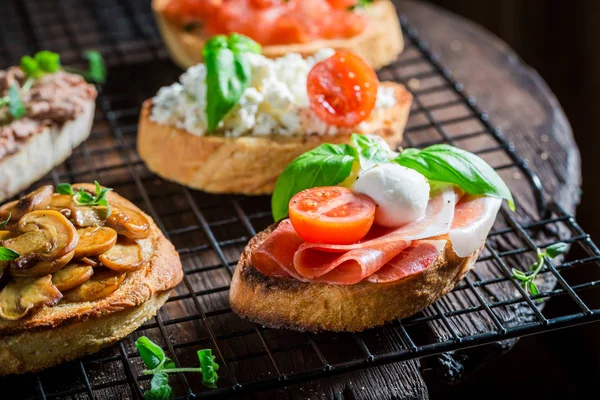 Bir şeyler atıştırmak için taze malzemelerle net çeşitli bruschetta — Stok fotoğraf