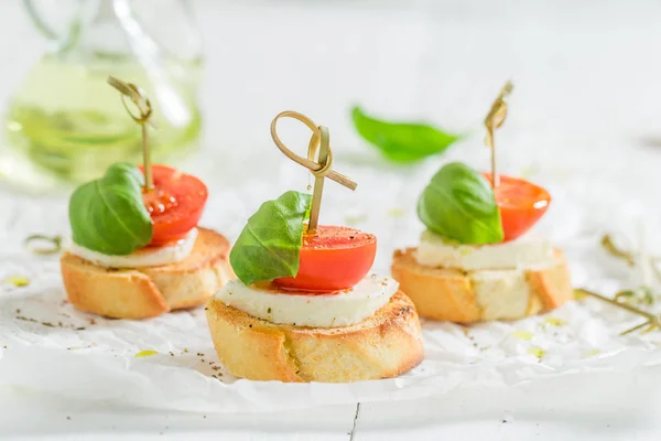 Fresh crostini with tomato, mozzarella and basil for a snack — Stock Photo, Image
