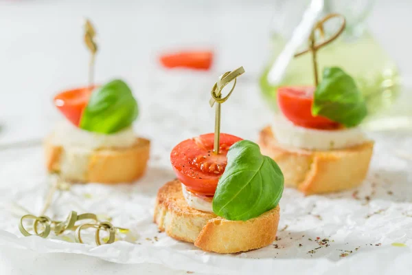 Delicious crostini with tomato, mozzarella and basil for a snack — Stock Photo, Image