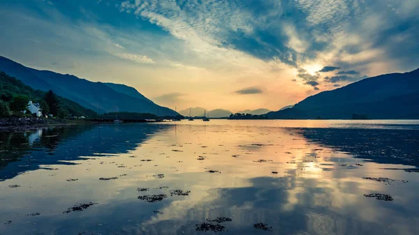 Farbenfroher Sonnenuntergang über den Booten auf dem See in Schottland — Stockfoto