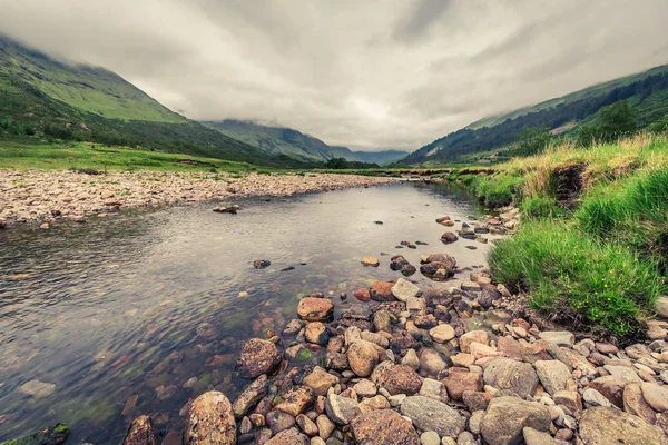 Fluss und Berg und Steine an einem nebligen Tag, Schottland — Stockfoto