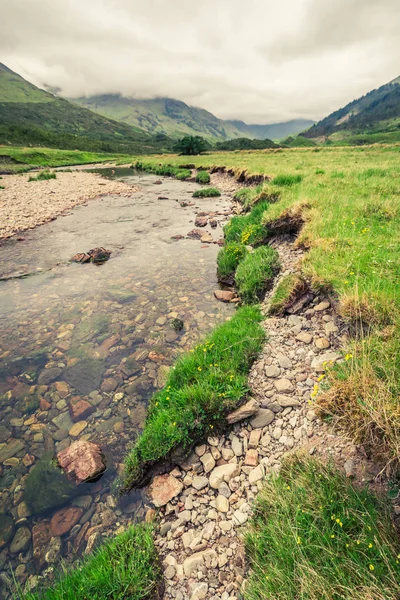 Pedras e rio e montanha em um dia nebuloso, Escócia — Fotografia de Stock