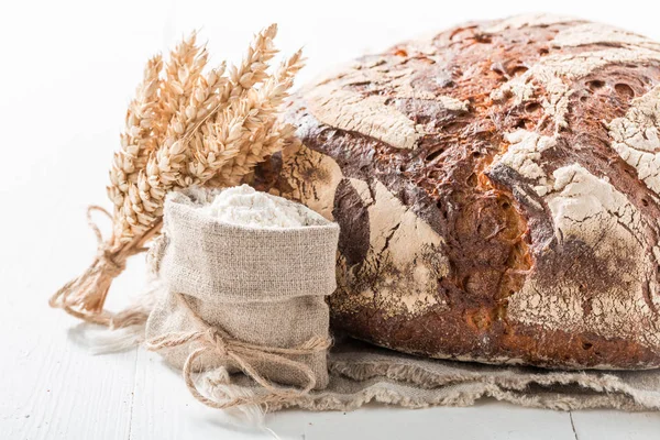 Deliziosa pagnotta di pane con cereali integrali sul tavolo bianco — Foto Stock