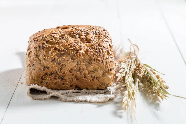 Sunne og ferske brød med flere korn på hvitt bord – stockfoto