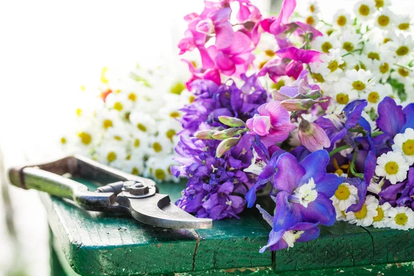 Mooie verschillende soorten bloemen op groene tabel — Stockfoto