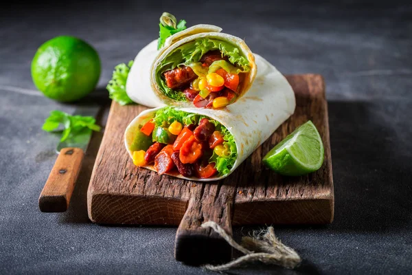 Sabroso burrito con verduras, salsa picante y lima — Foto de Stock