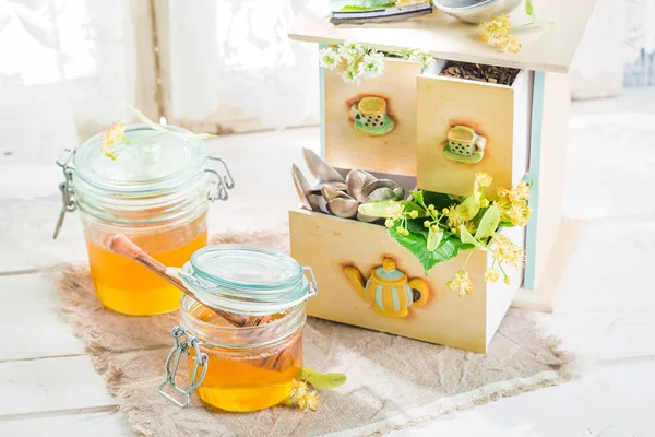 Gezonde zoete honing en verse linden bladeren — Stockfoto
