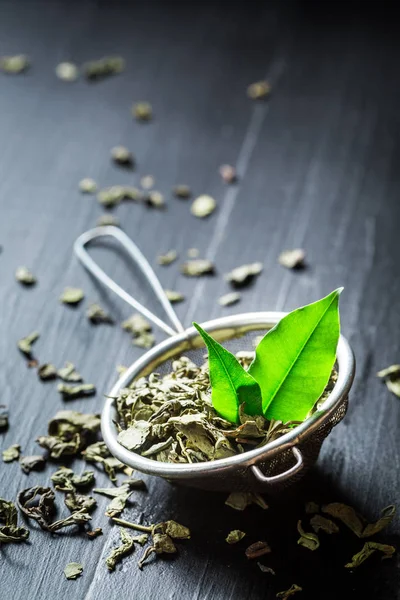 Delicioso té verde en colador de metal viejo —  Fotos de Stock