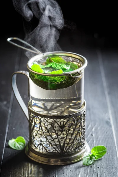 Brewing fresh green tea on old black table — Stock Photo, Image