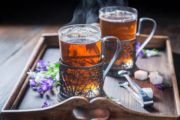 Smaker varm te på gammelt trebord. – stockfoto