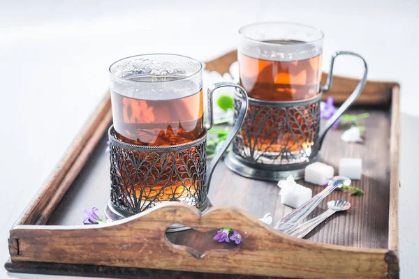 Tasty hot tea with fresh green leaves — Stock Photo, Image