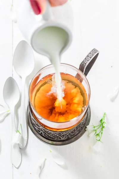 Bahar çiçekleri ile sıcak çay içine süt dökme — Stok fotoğraf