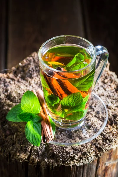Chá quente com folhas verdes e casca de canela — Fotografia de Stock
