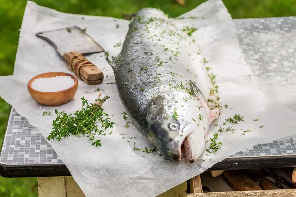 Trancher le saumon entier dans le jardin d'été pour le grill — Photo