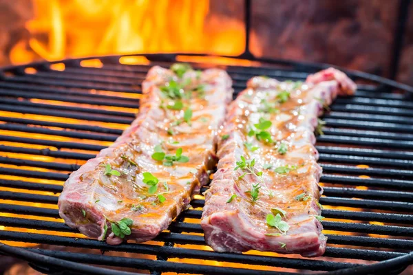 Tasty ribs with thyme and spices on grill — Stock Photo, Image