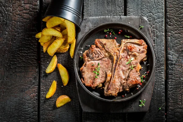 Nefis tbone biftek ve yanmış masanın üzerindeki fişlere — Stok fotoğraf