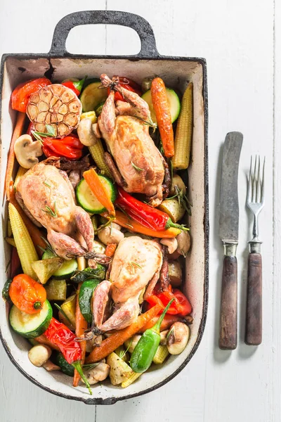 Codornices asadas con verduras en cazuela sobre fondo blanco —  Fotos de Stock