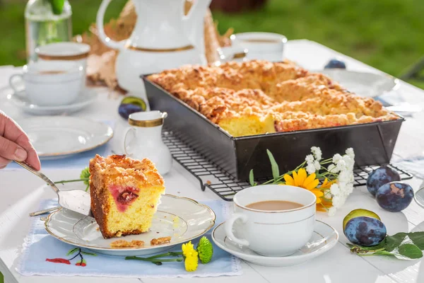 Sweet cake with plum served with coffee in summer garden — Stock Photo, Image