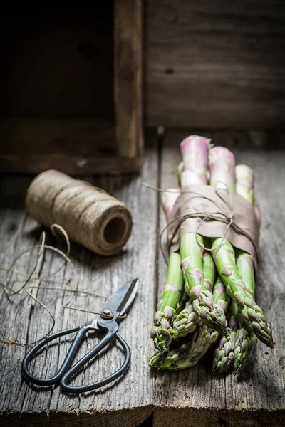 Espargos verdes saudáveis em uma cozinha rústica — Fotografia de Stock