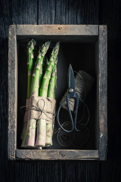 Свежая зеленая спаржа на деревенской кухне — стоковое фото